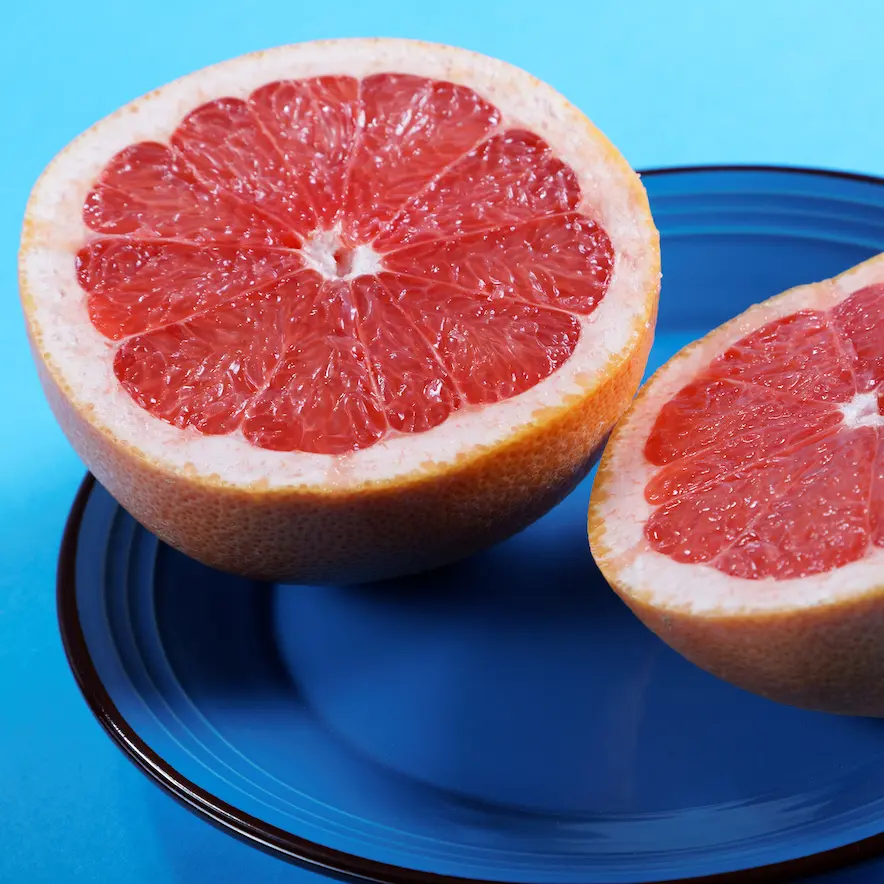 Ruby red grapefruit halfed on a blue plate. 